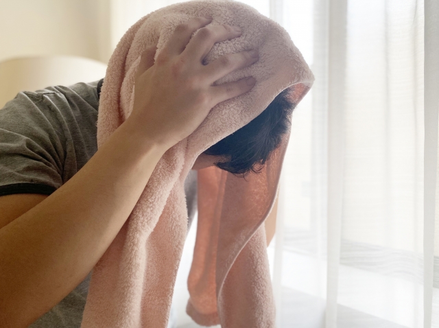 頭をタオルで拭く男性の画像